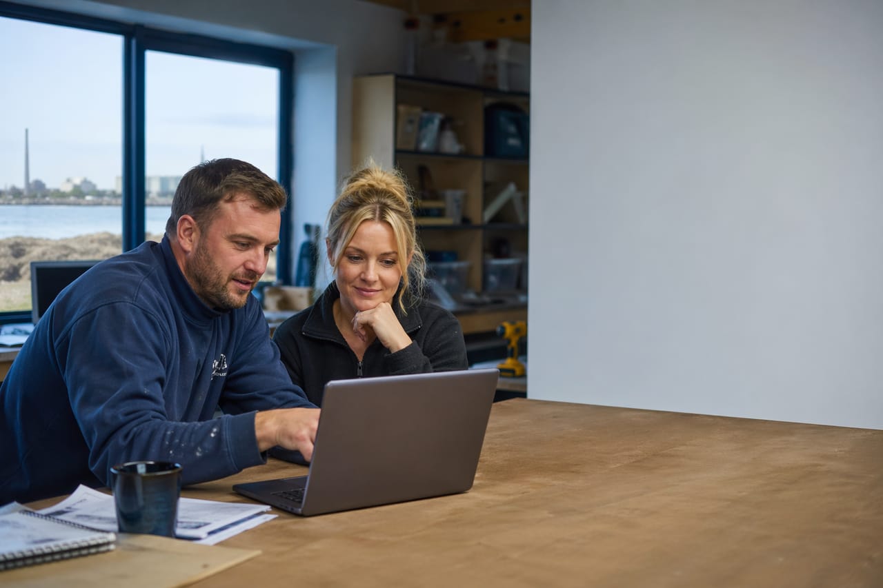 Small business owner and tradesperson reviewing a website design together