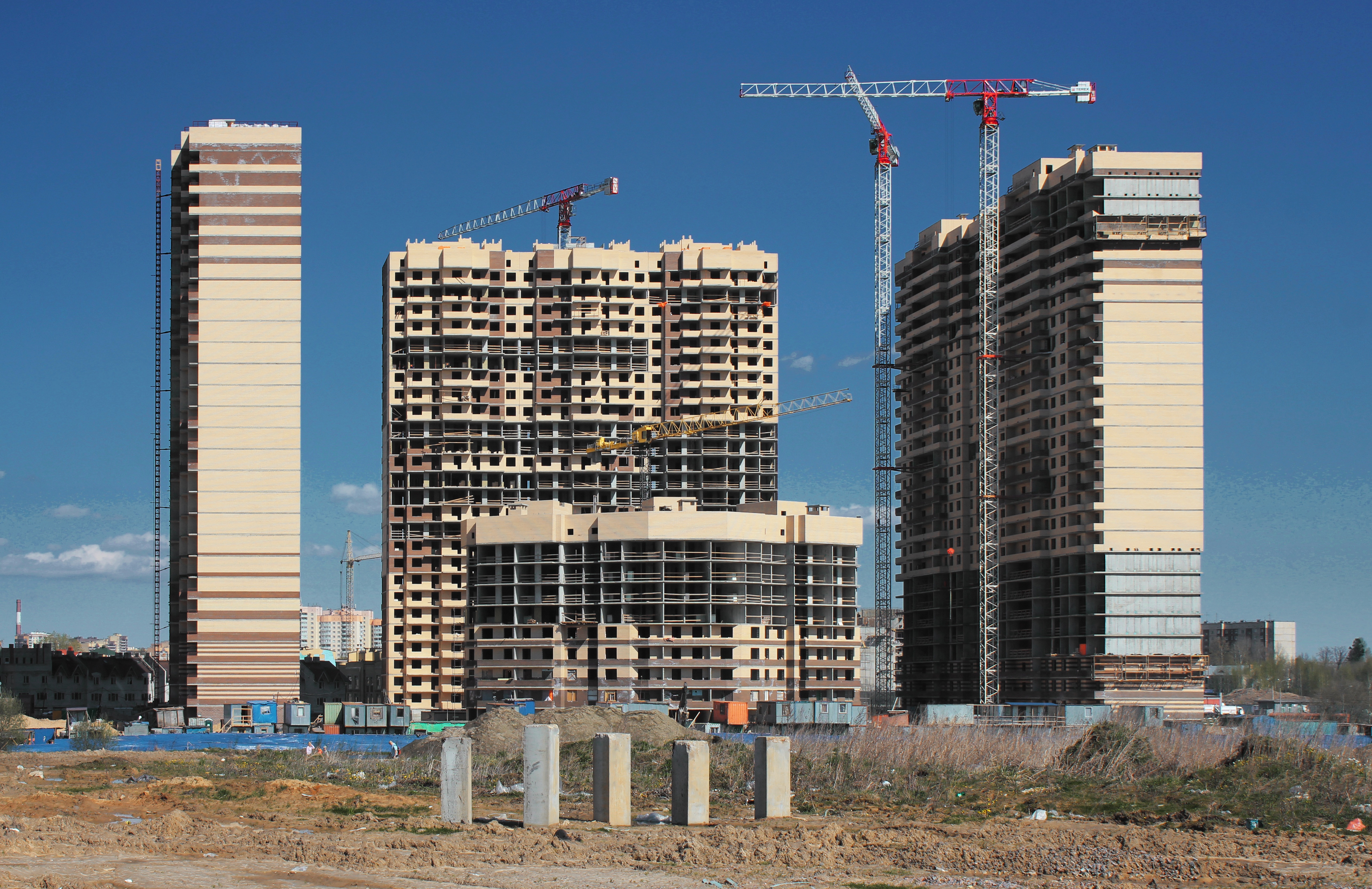 Active construction site with steel framework rising against a clear sky